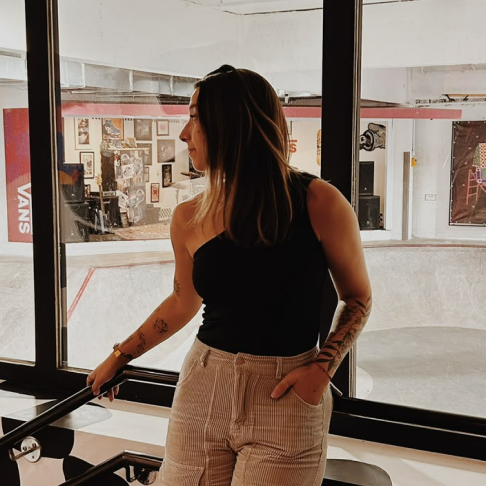 Luana apoiada em um corrimão em uma das lojas da Vans